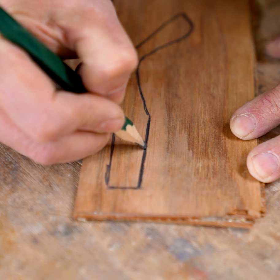 Disegno a mano della forma di una montatura in legno su una tavoletta artigianale.